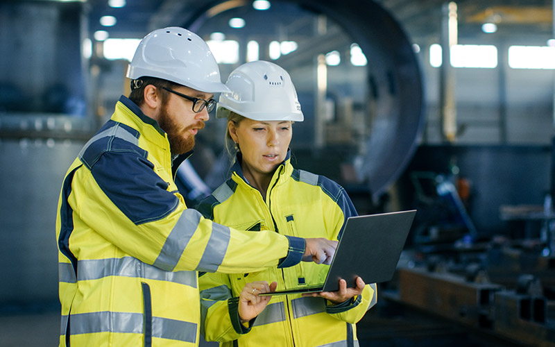 workers-in-safety-gear-using-laptop